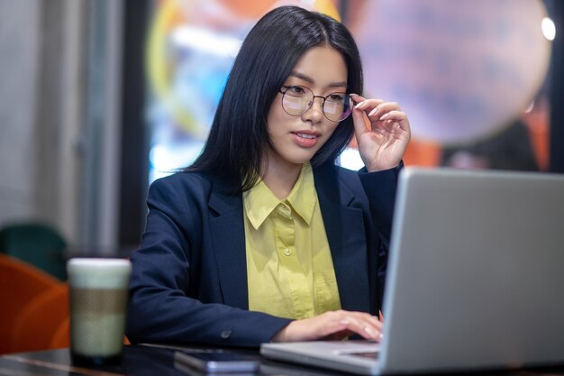 Aziatische zakenvrouw op kantoor die op een laptop werkt