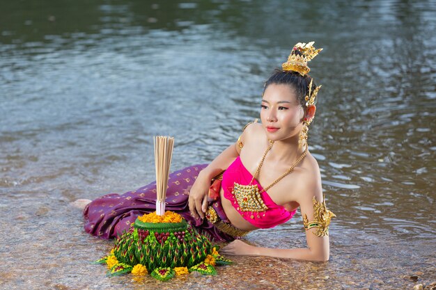 Azië vrouw in Thaise jurk traditionele greep kratong. Loy krathong-festival