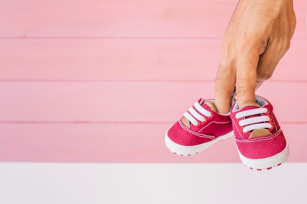 Gratis foto baby concept met vingers houden van schoenen