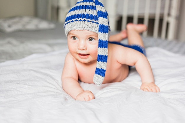 Baby die gestreepte gebreide hoed draagt