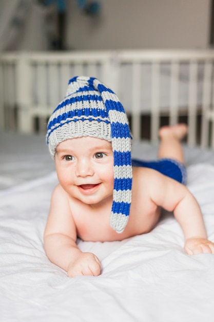 Baby die gestreepte gebreide hoed draagt