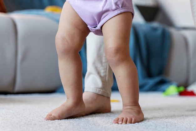 Baby leert lopen met de hulp van zijn moeder