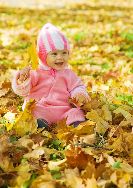 Baby met herfstbladeren