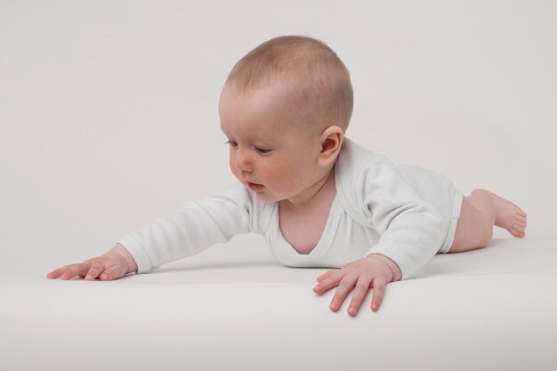 Baby op een witte achtergrond in een witte pyjama