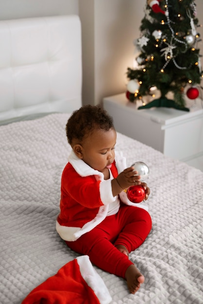 Gratis foto baby speelt met kerstbollen volledig schot