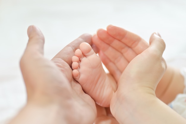 Baby voeten in de handen van de moeder.