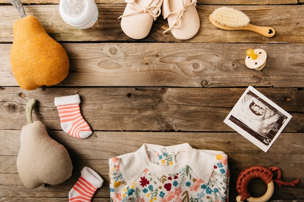 Babykleding en -producten gerangschikt in ronde vorm op houten tafel