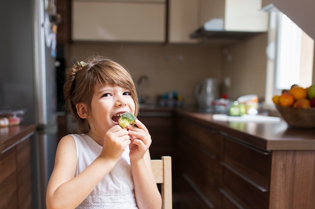 Gratis foto babymeisje die een snack hebben thuis