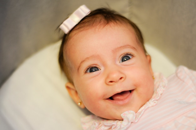 Babymeisje twee maanden oud die binnen glimlachen