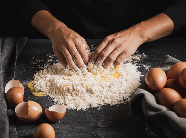 Baker handen mengen eieren met bloem