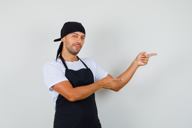 Gratis foto baker man wijst naar de zijkant in t-shirt