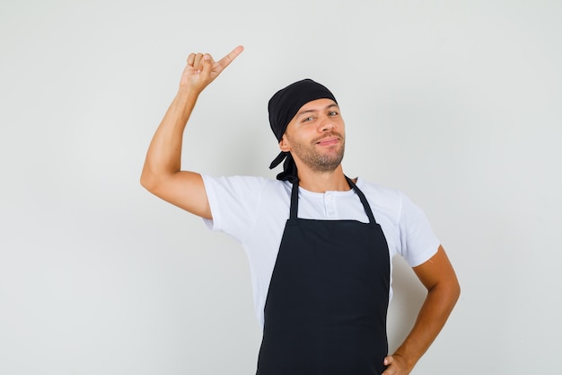 Baker man wijst naar de zijkant met vinger omhoog in t-shirt