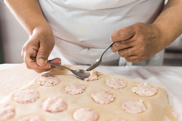 Gratis foto baker vult het beslag in een deeg op bakseldienblad met lepel