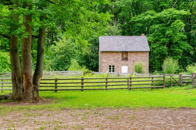 Bakstenen huis tussen groene bomen in het openluchtmuseum in het dorp Kommern, Eifelgebied, Duitsland