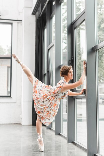 Ballerina stretching poseren in de buurt van de gesloten deur