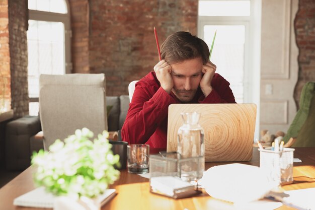 Bange krijger. Kaukasische ondernemer, zakenman, manager die op kantoor probeert te werken. Ziet er grappig uit, lui, tijd doorbrengend. Concept van werk, financiën, zaken, succes en leiderschap. Deadline, schiet op