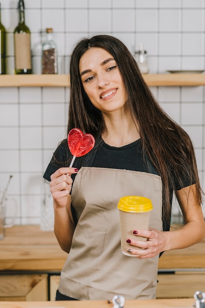 Gratis foto barista met kop en hartlolly