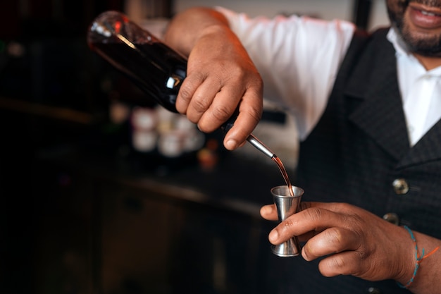 Gratis foto barman bereidt drankje aan de bar