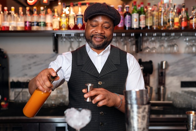 Gratis foto barman bereidt drankje aan de bar