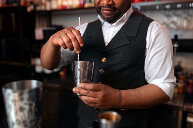 Gratis foto barman bereidt drankje aan de bar