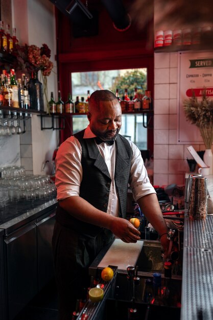 Gratis foto barman bereidt drankje aan de bar