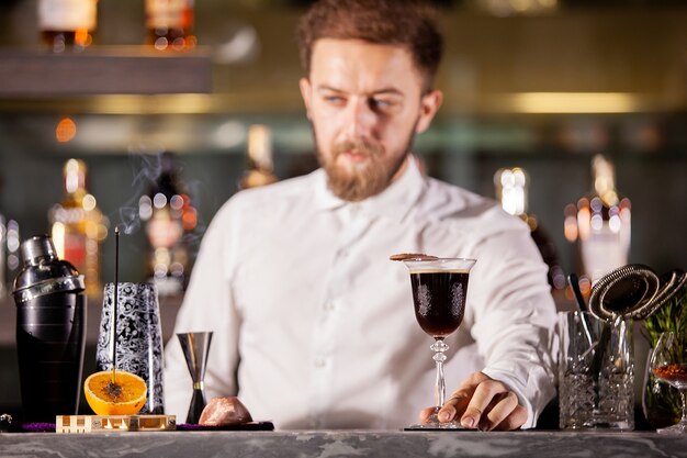 Barman presenteert koffiecocktail in loungebar. Gezellige sfeer
