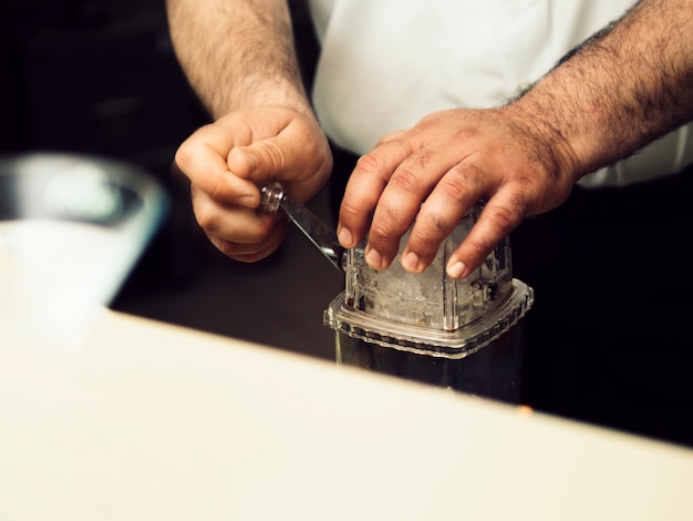 Gratis foto barman verpletterend ijs met barmateriaal