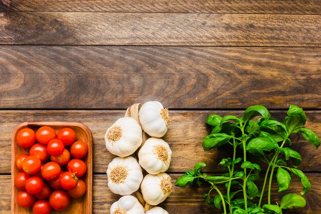 Basilicum in de buurt van knoflook en tomaten