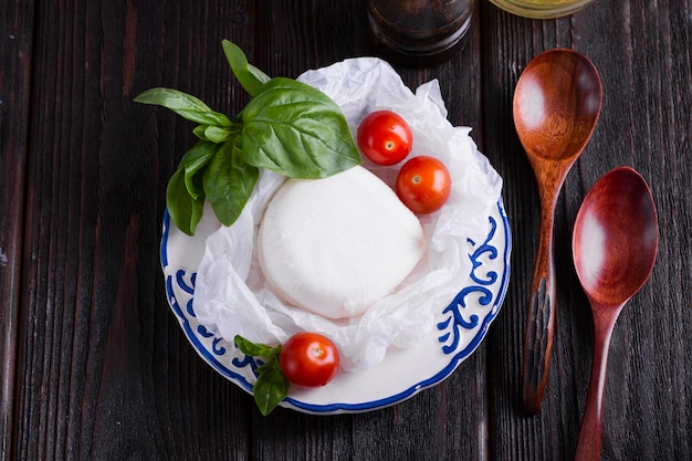 Basilicumbladeren en mozarella op een plaat