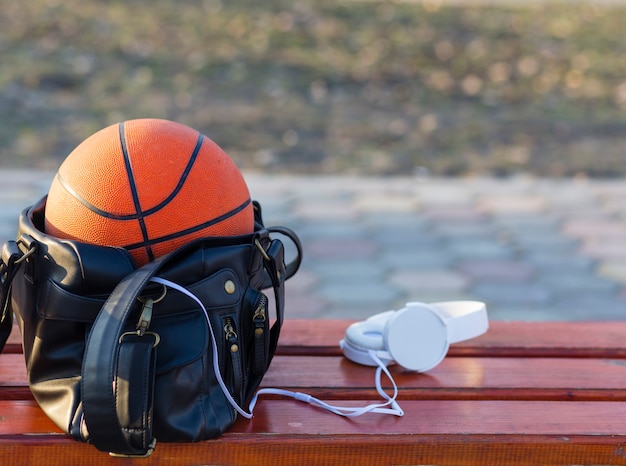 Gratis foto basketbal in een tas met koptelefoon