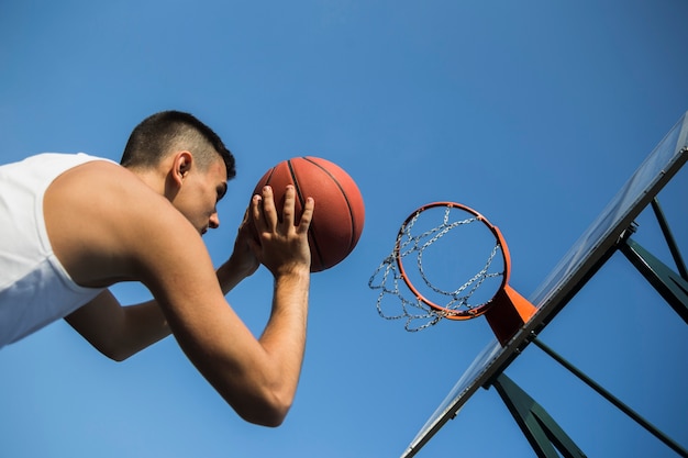 Basketbalspeler die bal in net werpt