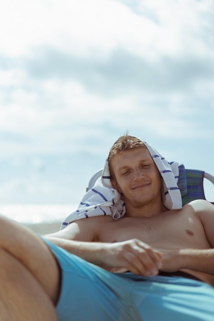 Beach Miami Florida USA, een jonge man die op het strand rust in een ligstoel.