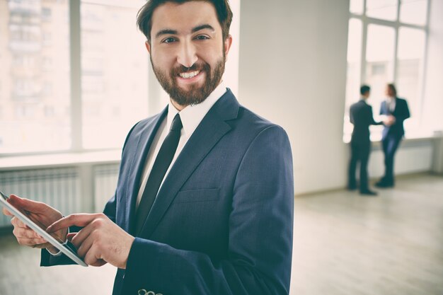 Bearded werknemer het werken met tablet