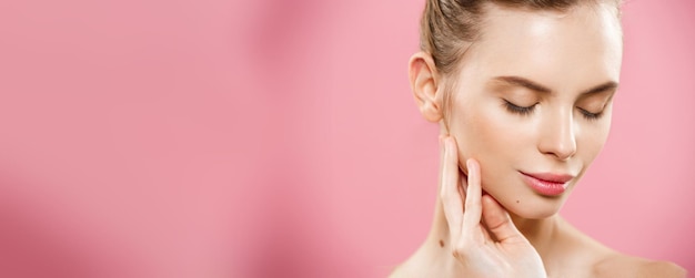 Beauty Concept close-up portret van aantrekkelijke blanke meisje met schoonheid natuurlijke huid geïsoleerd op roze achtergrond met kopie ruimte