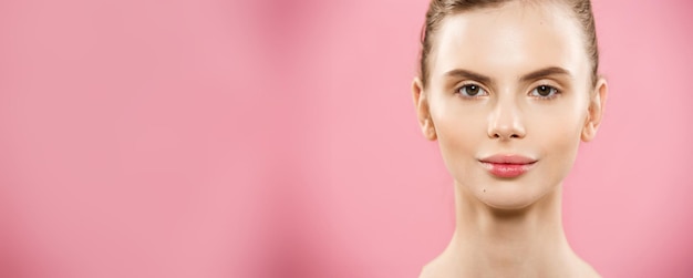 Beauty concept close-up portret van aantrekkelijke blanke meisje met schoonheid natuurlijke huid geïsoleerd op roze achtergrond met kopie ruimte