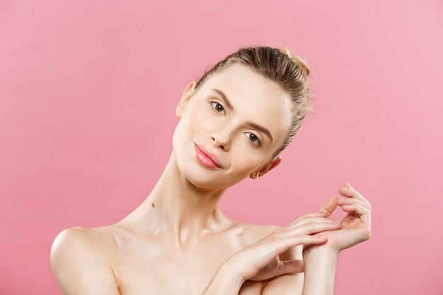 Beauty Concept - Mooie blanke vrouw met schone huid, natuurlijke make-up geïsoleerd op fel roze achtergrond met kopie ruimte.