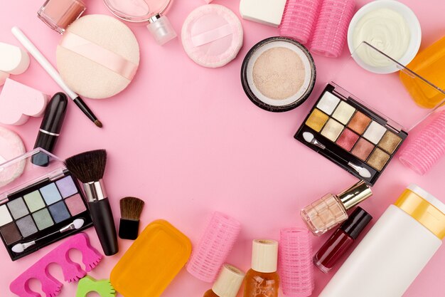Beauty Spa Feminine Concept. Verschillende Make-up Beauty Care Essentials Cosmetica op Flat Lay Pink Background. Top View. Bovenstaand.