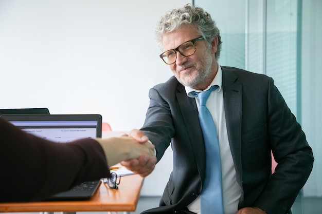 Gratis foto bebaarde kaukasische uitvoerend manager, handenschudden en glimlachen