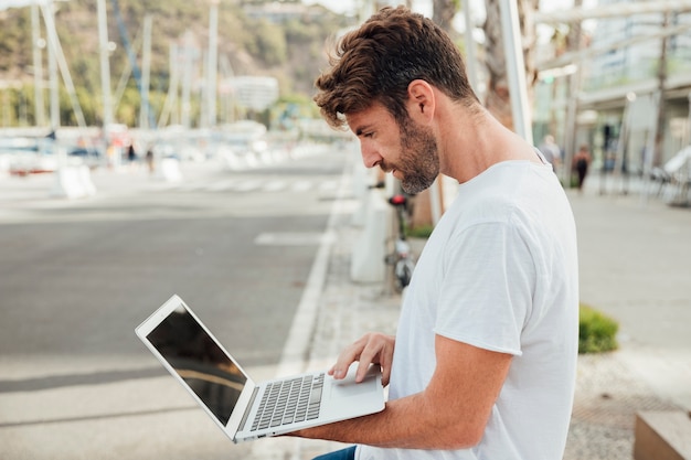 Bebaarde laptop van de mensenholding openlucht