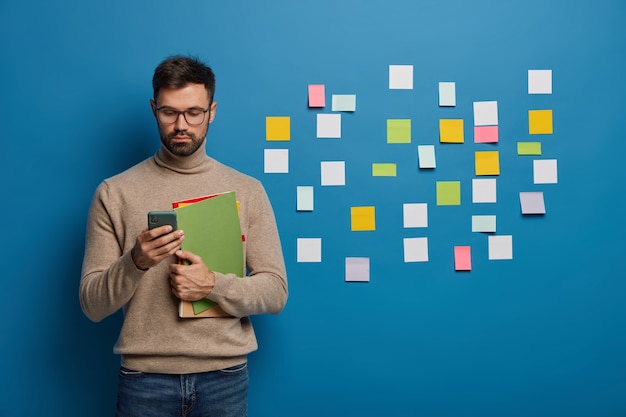 Bebaarde man die zijn taken organiseert met behulp van plaknotities