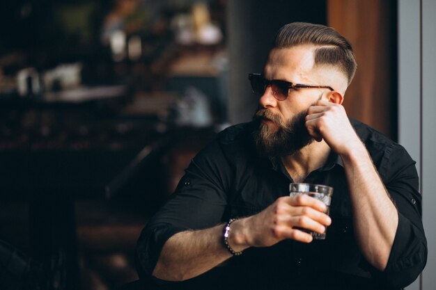 Bebaarde man drinken in een bar