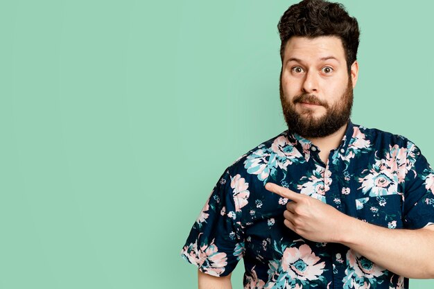 Bebaarde man in gebloemd zomershirt wijzend naar de zijkant