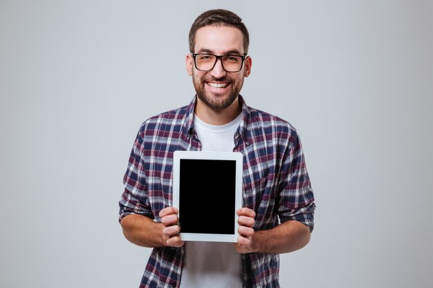 Bebaarde man in oogglazen met lege tablet-computerscherm