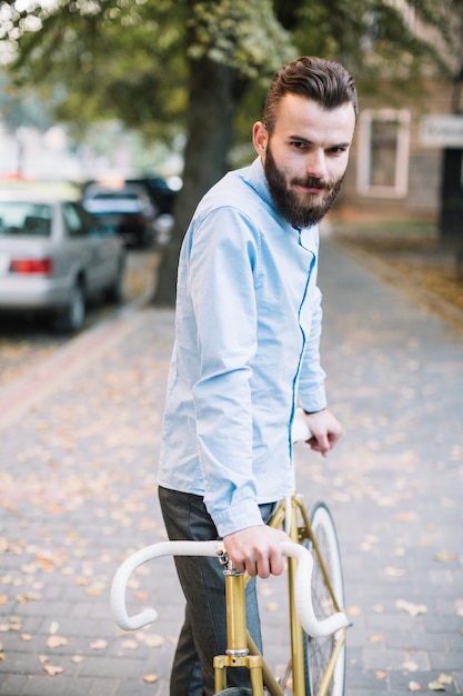 Bebaarde man met fiets camera kijken