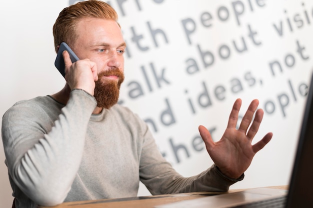 Gratis foto bebaarde man praten aan de telefoon