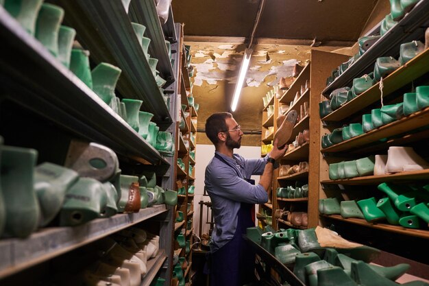 Bebaarde schoenmaker met bril vond de juiste schoenvorm voor zijn nieuwe collectie.