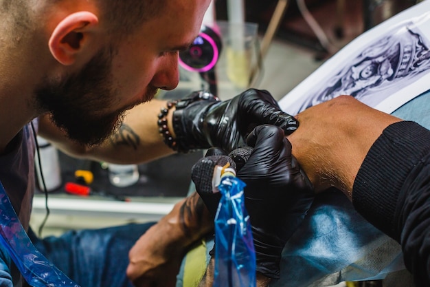 Bebaarde tattoo-artiest werkt