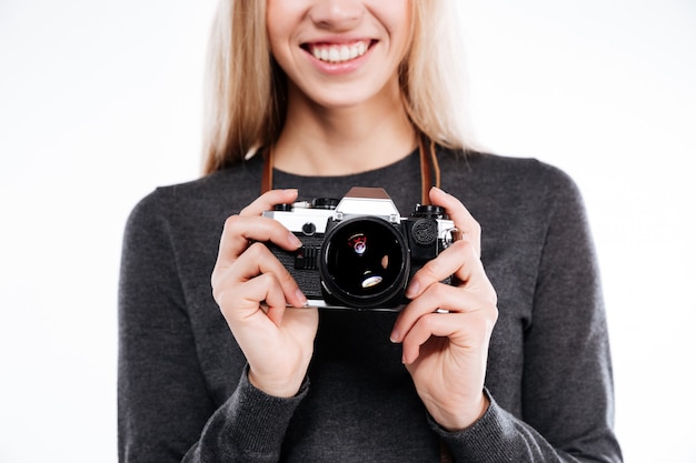 Bebouwd beeld van een glimlachend blondemeisje die retro camera houden