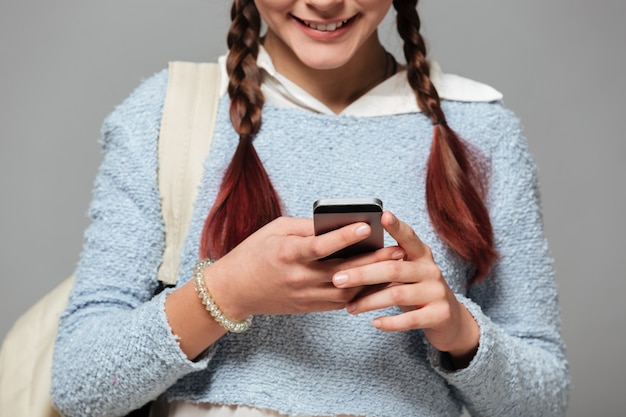 Bebouwd beeld van een glimlachend schoolmeisje met rugzak