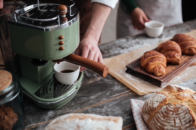 Bebouwd beeld van jonge bakkers die zich bij bakkerij het drinken koffie bevinden.